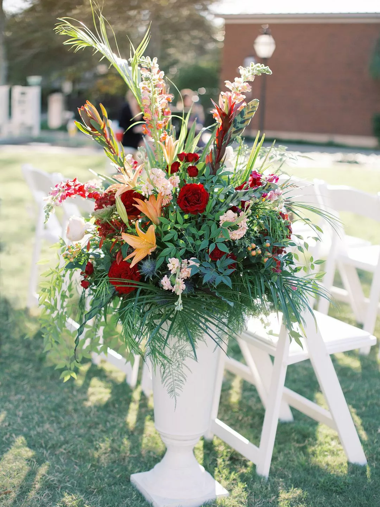 A vibrant floral arrangement with red roses and orange lilies. 