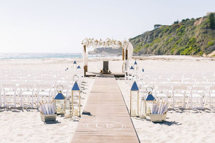 A custom wooden walkway imprinted with Leah and Brian's initials served as the aisle, which led the couple to an arch made with white blossoms and draped with white fabric.