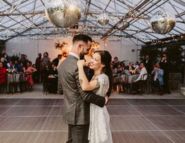 Bride and groom dancing during first dance under disco balls at reception