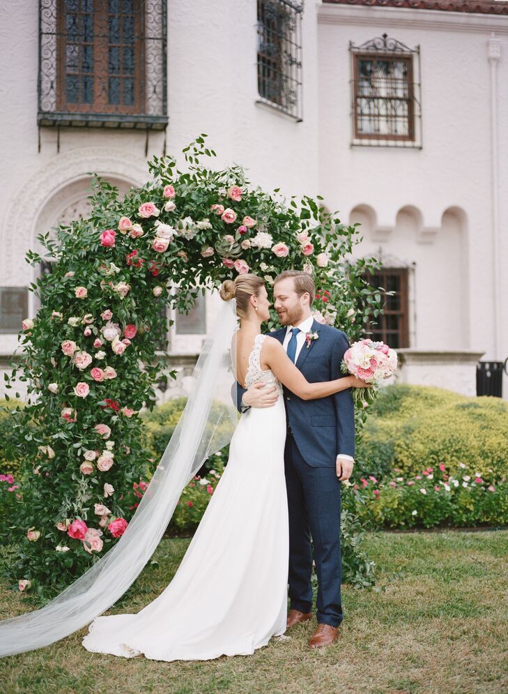 Alicia and Ian said “I do” under an arch covered in greenery and pink garden roses.