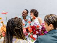 A couple lean in together, smiling, at this outdoor rehearsal dinner.