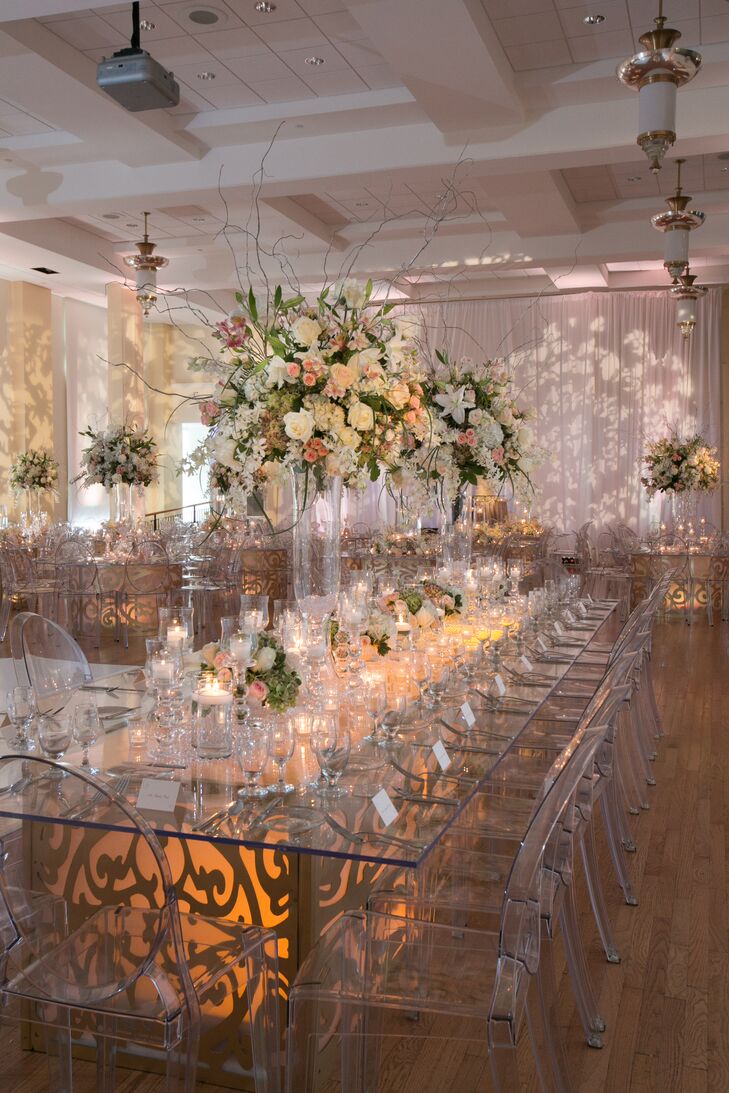 Soft gold uplighting softened the room while candles added a romantic vibe. Large floral centerpieces and glass tables completed the couple’s ethereal glass palace vibe.
