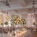 Soft gold uplighting softened the room while candles added a romantic vibe. Large floral centerpieces and glass tables completed the couple’s ethereal glass palace vibe.