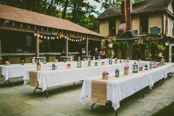 Small, DIY arrangements of paper flowers and lanterns were set out on each of the farmhouse tables, which were covered with burlap table runners.