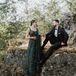 Bride in Emerald Green Lengha Dress and Groom in Classic Tuxedo Holding Hands Before Their Sikh Reception