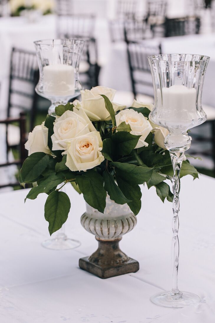 The couple had tall crystal candlesticks and silver urns filled with white roses for their centerpieces.
