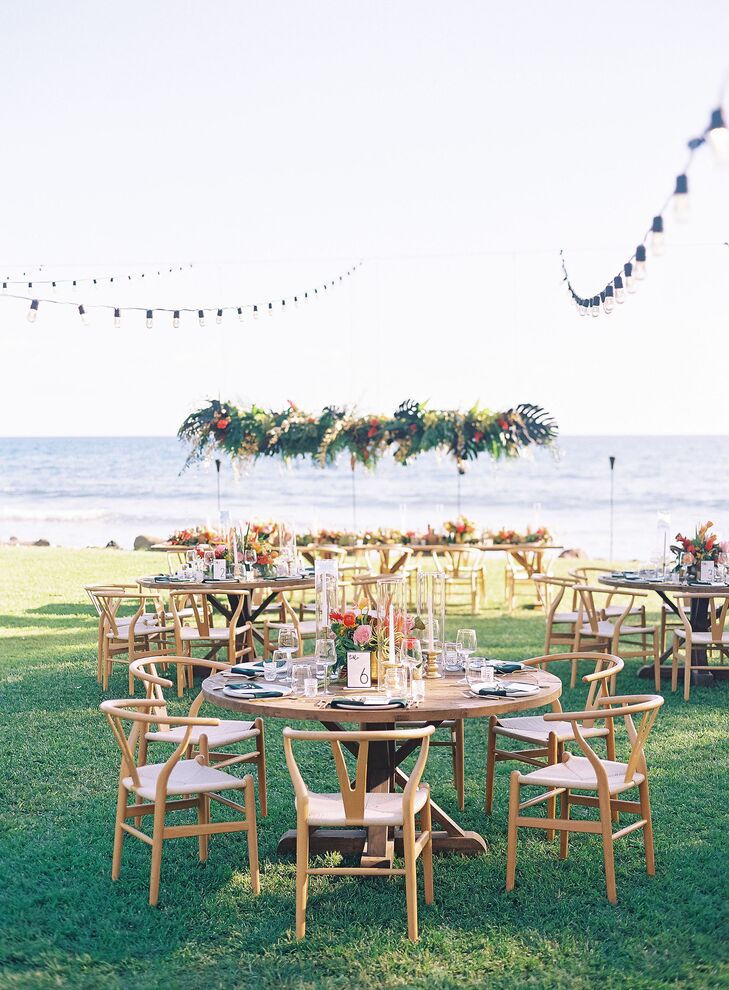 Simple Wood Tables Under String Lights With Suspended Flower Arrangement, String Lights