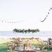 Simple Wood Tables Under String Lights With Suspended Flower Arrangement, String Lights