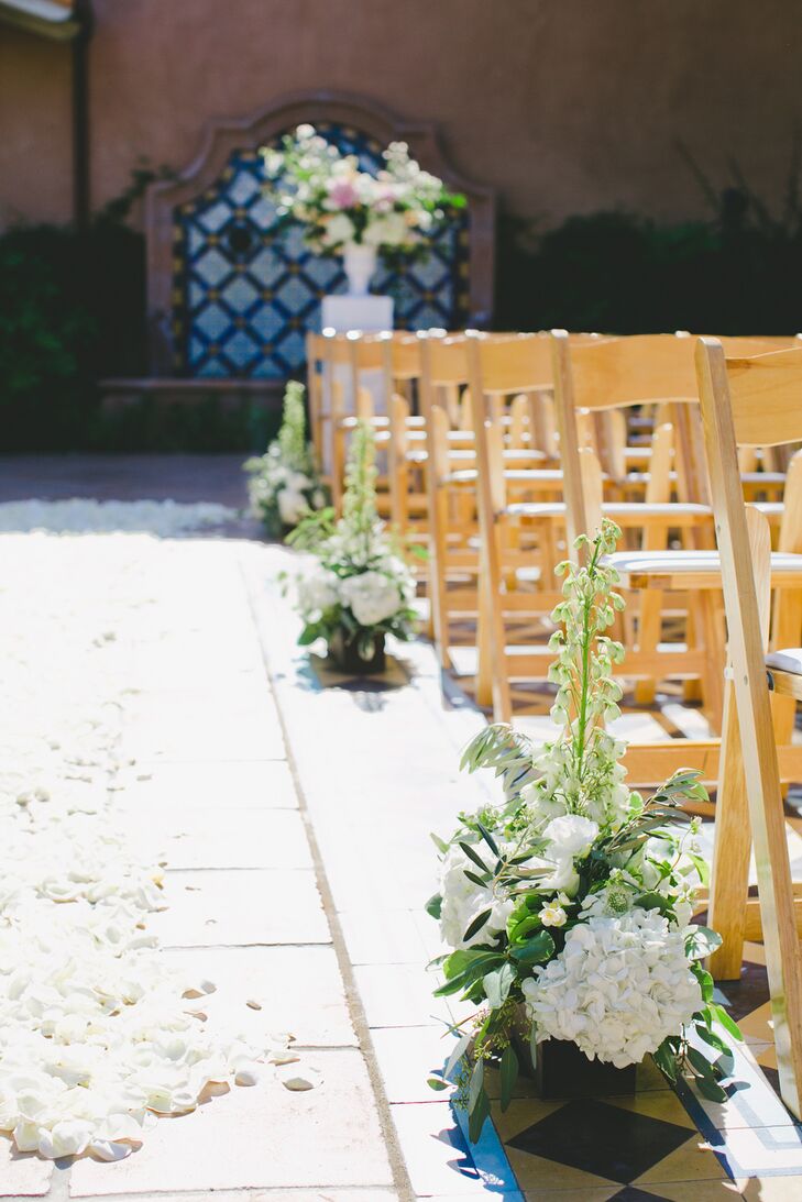 To bring the Rancho Valencia courtyard to life for the ceremony, Michelle Jacob lined the aisles with ivory rose petals and arrangements of white hydrangeas, delphiniums and textured greenery.