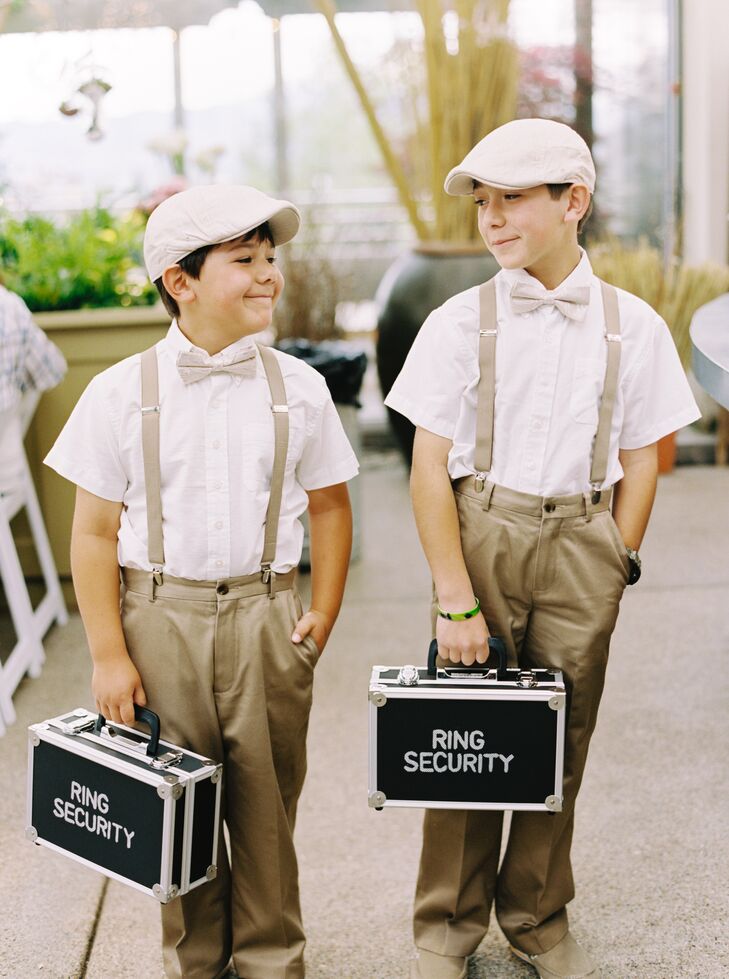 These adorable ring bearers dressed in neutral slacks with suspenders, bow ties and a cap for a vintage paper boy look, and each carried briefcases labeled “Ring Security.”