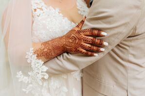 Bride in Wedding Dress and Henna Hand With Groom in Tan Suit