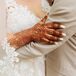 Bride in Wedding Dress and Henna Hand With Groom in Tan Suit