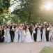 Wedding Party in Pale Blue and Black Smiles While Bride and Groom Kiss