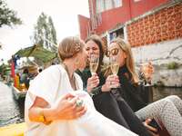 Three women enjoying champagne on a boat for bachelorette party
