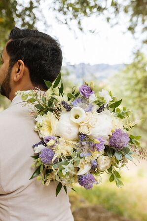 Colorful White and Lavender Bridal Bouquet Held Behind Groom
