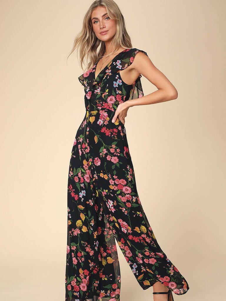 Model wearing a jumpsuit with ruffled accents and a black floral print 