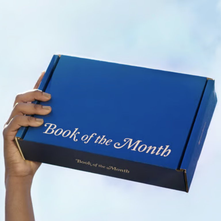 Person holding up blue book of the month subscription box luxury gift idea for wife