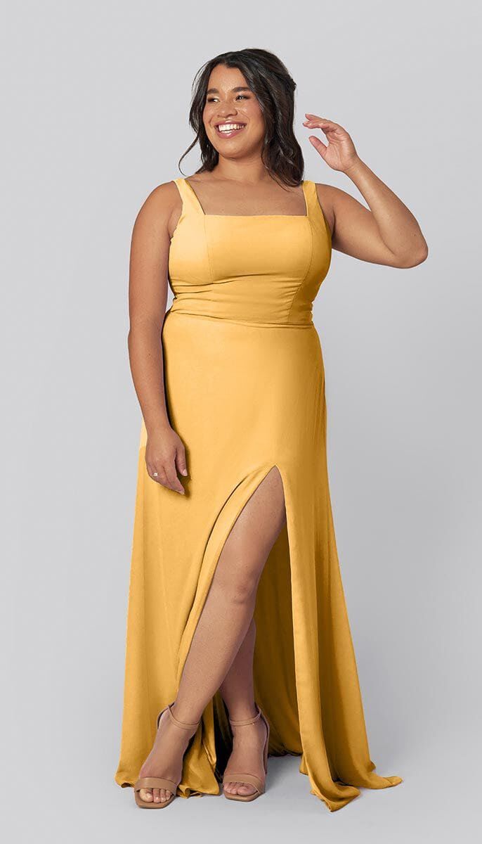 Model wears a yellow dress with an elegant slit on the side. 