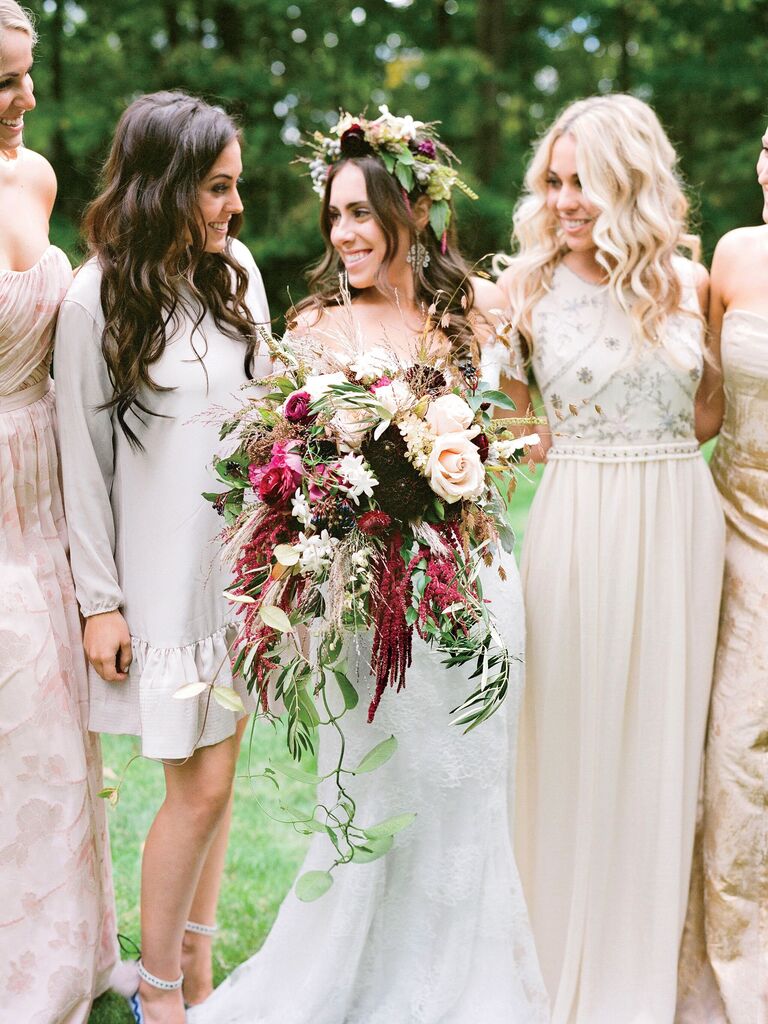 bride walks with bridesmaids carrying oversized boho cascading wedding bouquet with red amaranthus, pampas grass and greenery