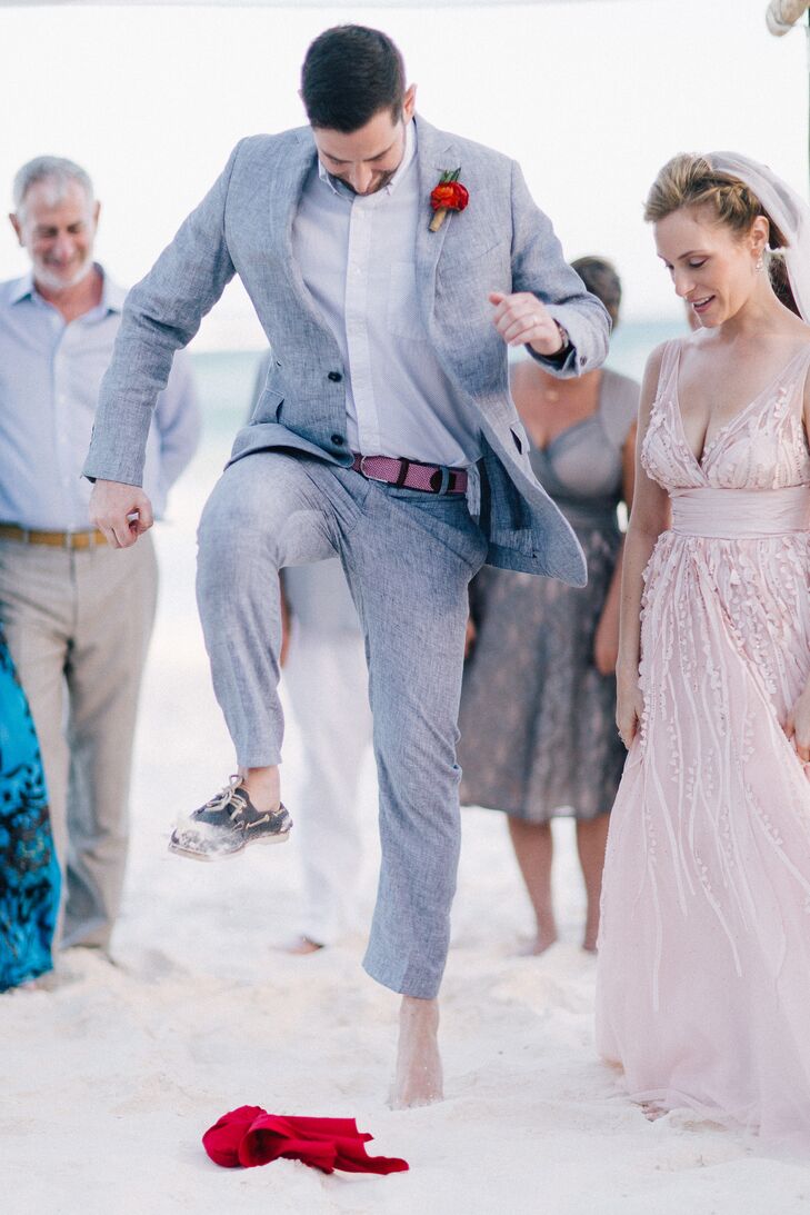 Jason wore a gray linen suit from Louis Purple in New York, with a pink belt and strawberry red boutonniere. He and Danielle participated in the Jewish tradition of breaking the glass to make their marriage official—and they weren’t about to let the sand get in their way.