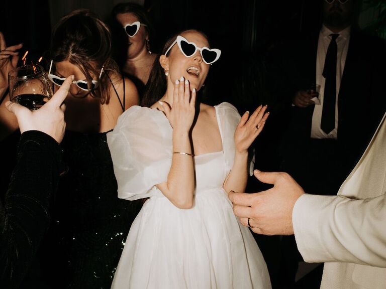 Brides wearing heart sunglasses at reception