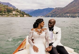 The happy couple share a moment together on a boat in the middle of a lake