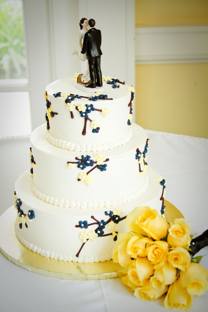 The white wedding cake was decorated with sugar designs depicting flowers on tree branches, topped with classic bride and groom figurines. "We absolutely loved the three-tier cake, which included red velvet, white cake and lemon cake, with layers of buttercream and cream cheese throughout."