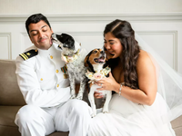 A happy married couple enjoy a snuggle moment with their two dogs.
