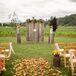 The couple was married at an altar surrounded by wood pillars and rustic wood panel backdrop at Craven Farm in Snohomish, Washington. The aisle was decorated with wildflower arrangements, drapery and colorful petals.