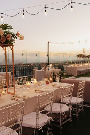 Long Tables and Lounge Furniture Under String Lines at a Rooftop Reception