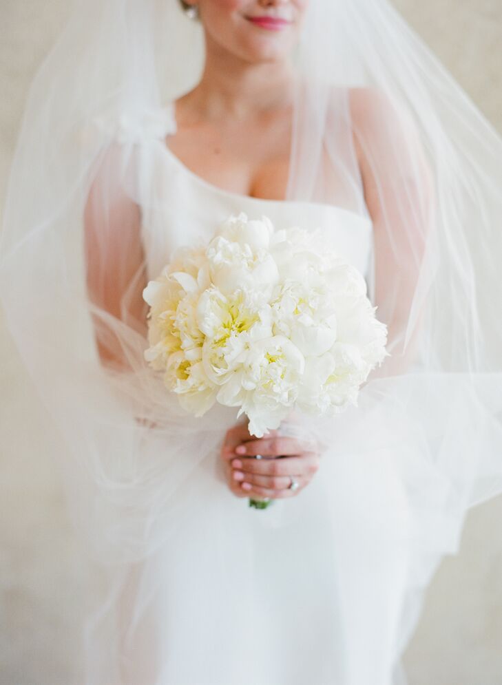 Lynn carried a perfectly round bouquet of white peonies for her modern wedding. “I love the way peonies smell and how they look,” she says. “I knew I wanted these for my bouquet.”