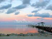 Dock on the water at sunset