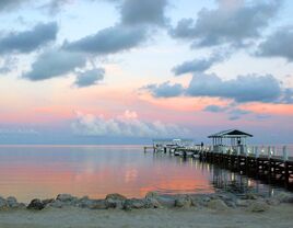 Dock on the water at sunset