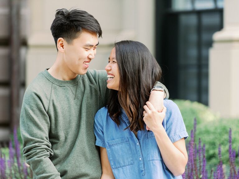 Couple holding hands and laughing during engagement session