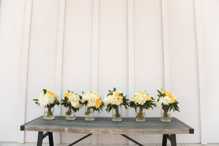 Ashleigh and her bridesmaids carried bouquets of yellow and white flowers with leafy accents down the aisle at the ceremony.
