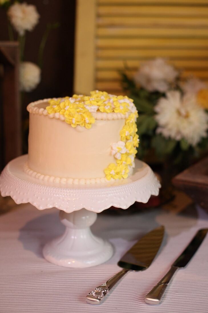 The couple's wedding cake was a yellow and white confection that was a single tier decorated with yellow hydrangea sugar flowers.