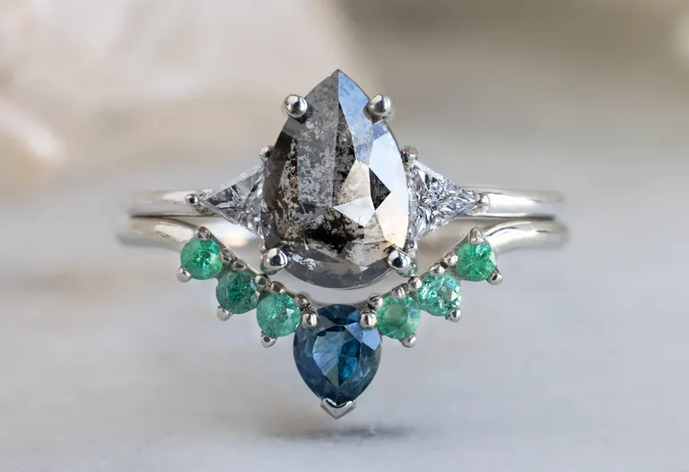 stackable ring with six round emeralds and Montana sapphire