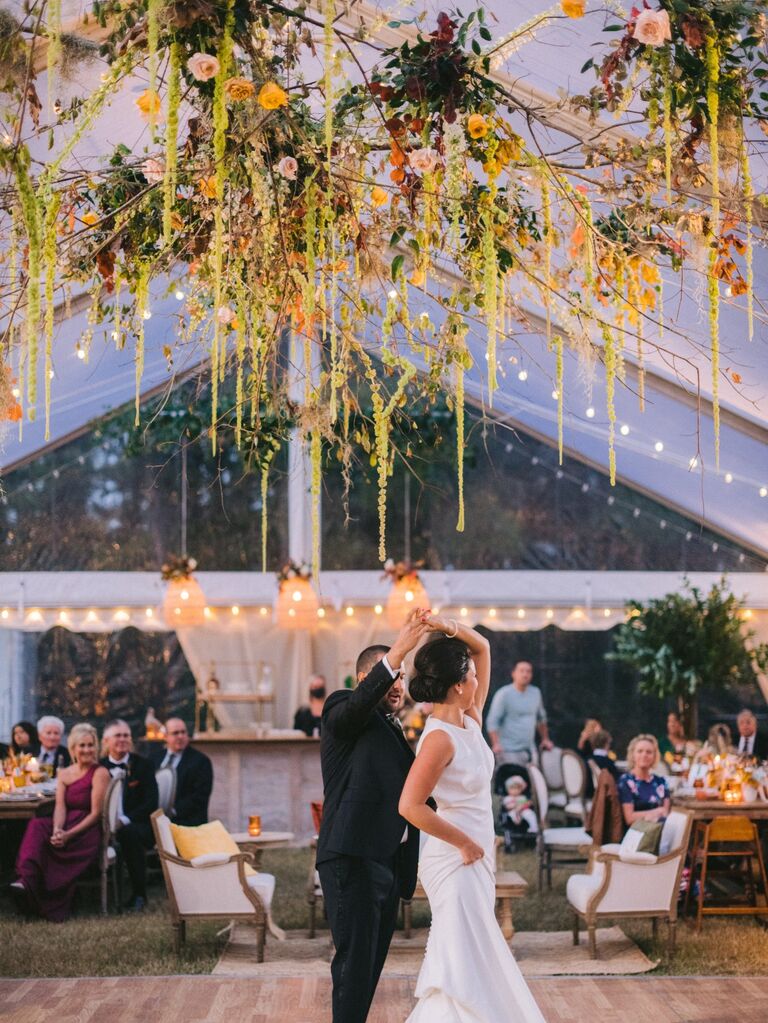 Couple dances under a green and orange display. 