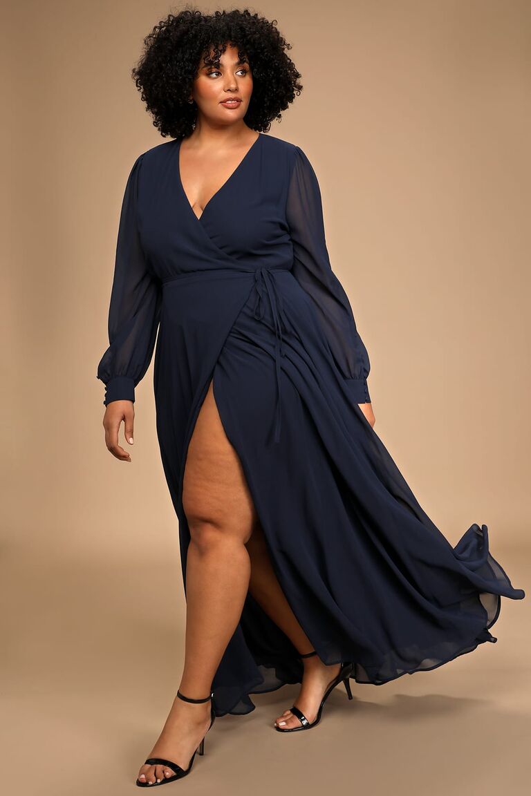 Model wears a long-sleeved dress with a tied waist and a slit on the side. 