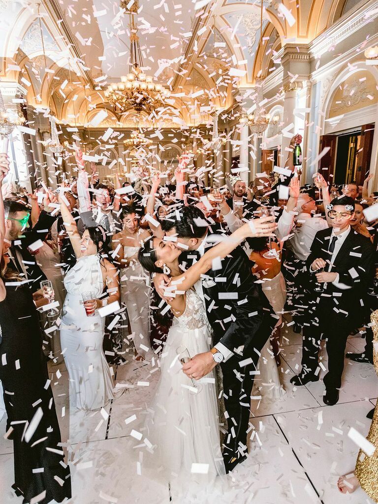 Bride and groom dancing with wedding party at reception