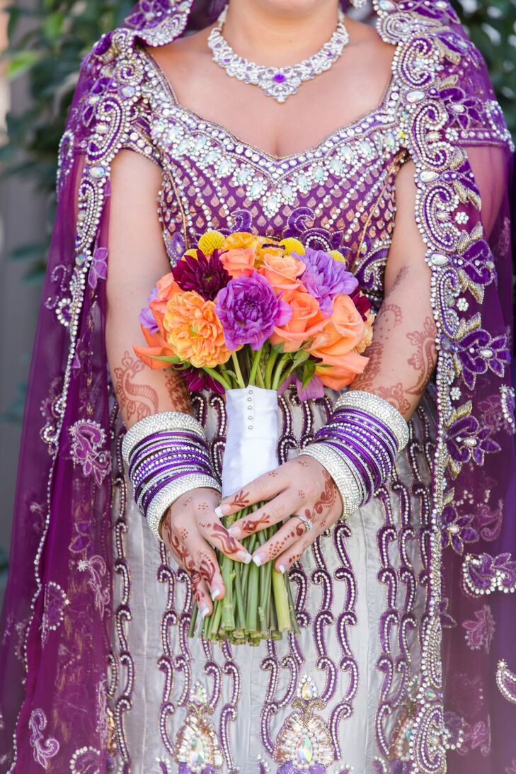 Samantha held a orange, red and purple arrangement of peonies, dahlias and roses.