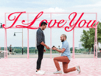 Man on one knee proposing to his fiance. 