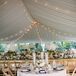 For their round reception tables, Tiffany and Joe chose something simple and classic. Florists from Viburnum Designs arranged each low centerpiece with white hydrangeas, white peonies, blush roses and hints of gold-seeded eucalyptus. Tall white candlesticks in cylinder glass vases surrounded each one.