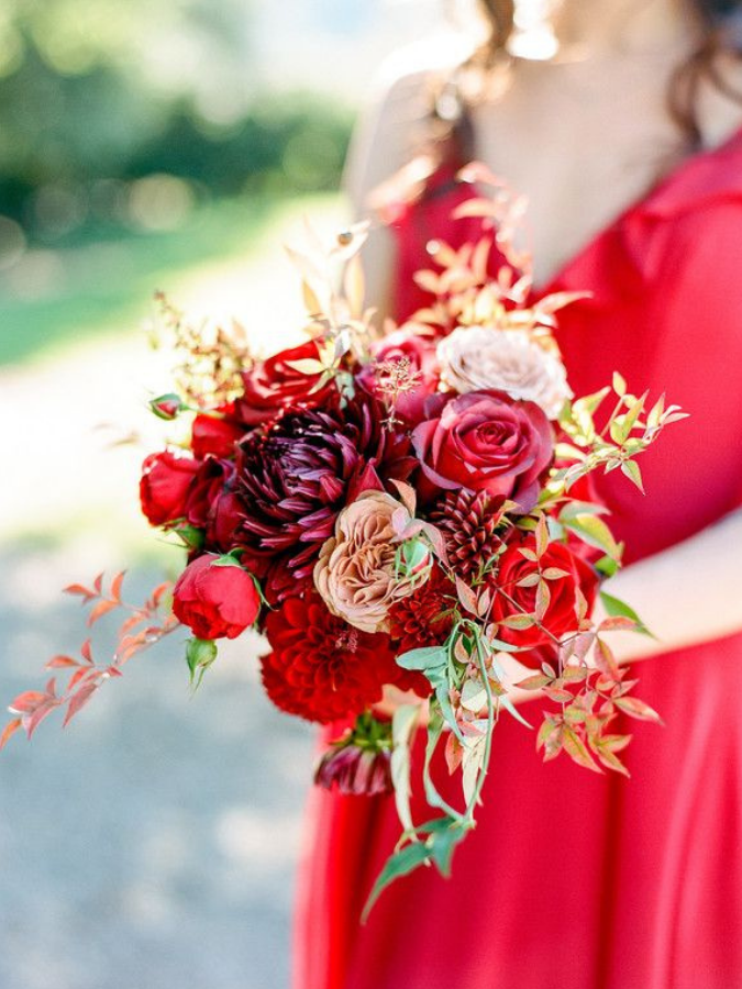 Bridesmaid in red dress holding red bouquet