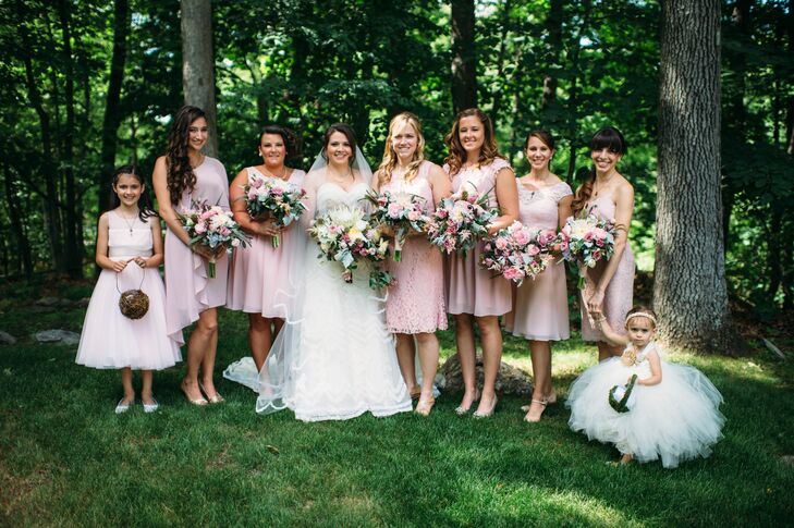 Each bridesmaid sported her favorite knee-length dress in the couple’s romantic pink, blush and mauve wedding colors. Their mixed hairstyles, neutral shoes and delicate jewelry added to the day’s theme. The bouquets from Ibranyi Is Floral tied everything together. Each woman carried an overflowing arrangement of pink roses, dusty miller, white roses, seeded eucalyptus and fiddlehead fern shoots for a whimsical touch. The couple's flower girl and junior bridesmaid stood out among them with all-white dresses and natural baskets.