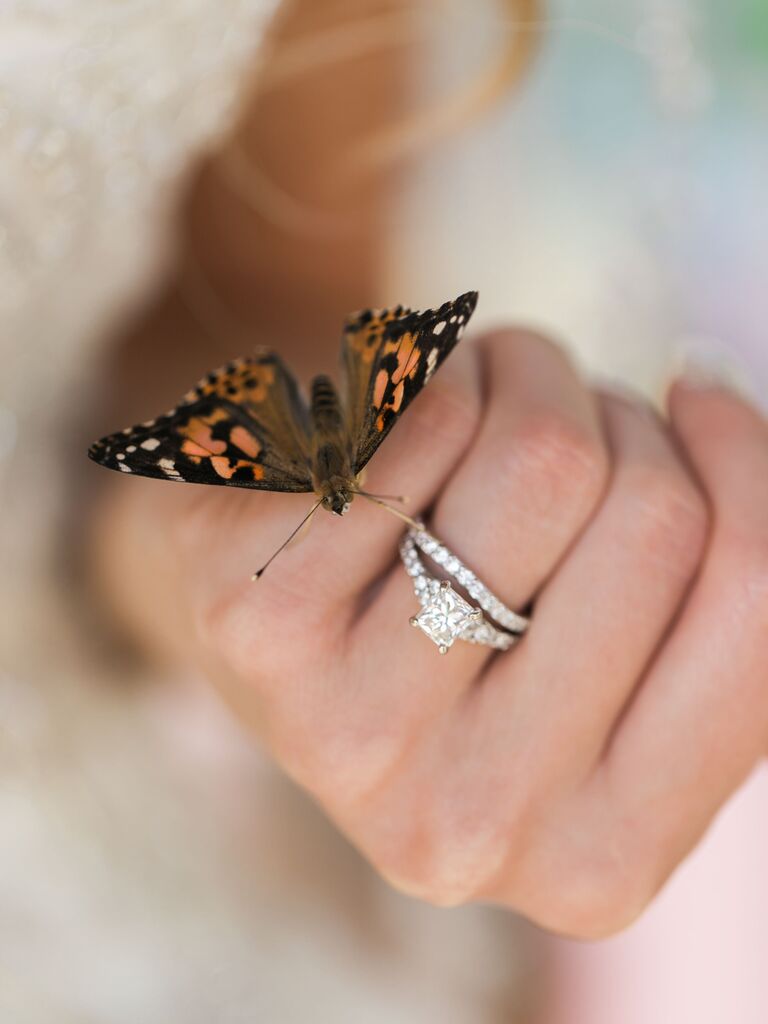 Bride holding butterfly after wedding ceremony. 