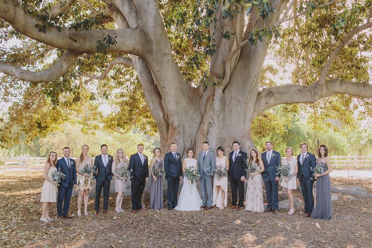 The couple stood in the middle of their wedding party underneath a grand tree at Camarillo Ranch in Camarillo, California. The bridesmaids picked their dresses, which followed the general neutral-colored palette. The groomsmen wore charcoal gray suits with neutral-colored ties to fit the color palette as well.