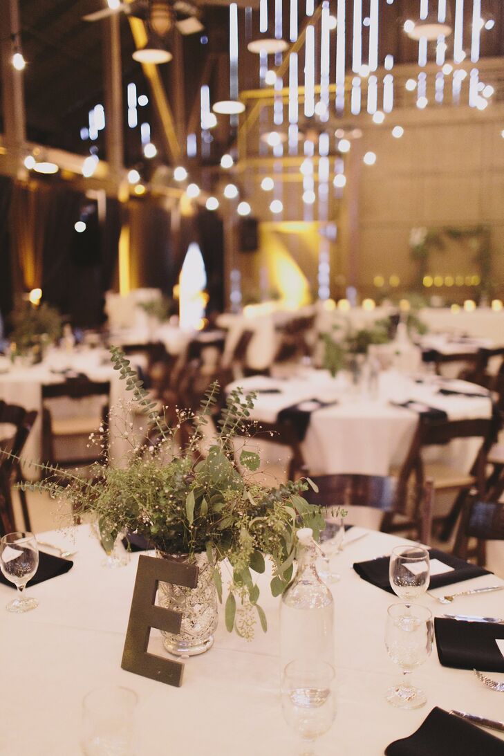 The room inside the barn was flipped after the ceremony, making space for the circular white dining tables decorated with lush centerpieces made of leaves and eucalyptus. Tables were each marked by a wooden letter so guests could find their seats.