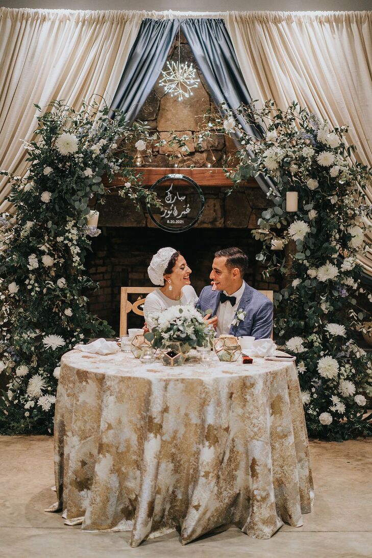 Bride and Groom at Floral-Filled Sweetheart Table