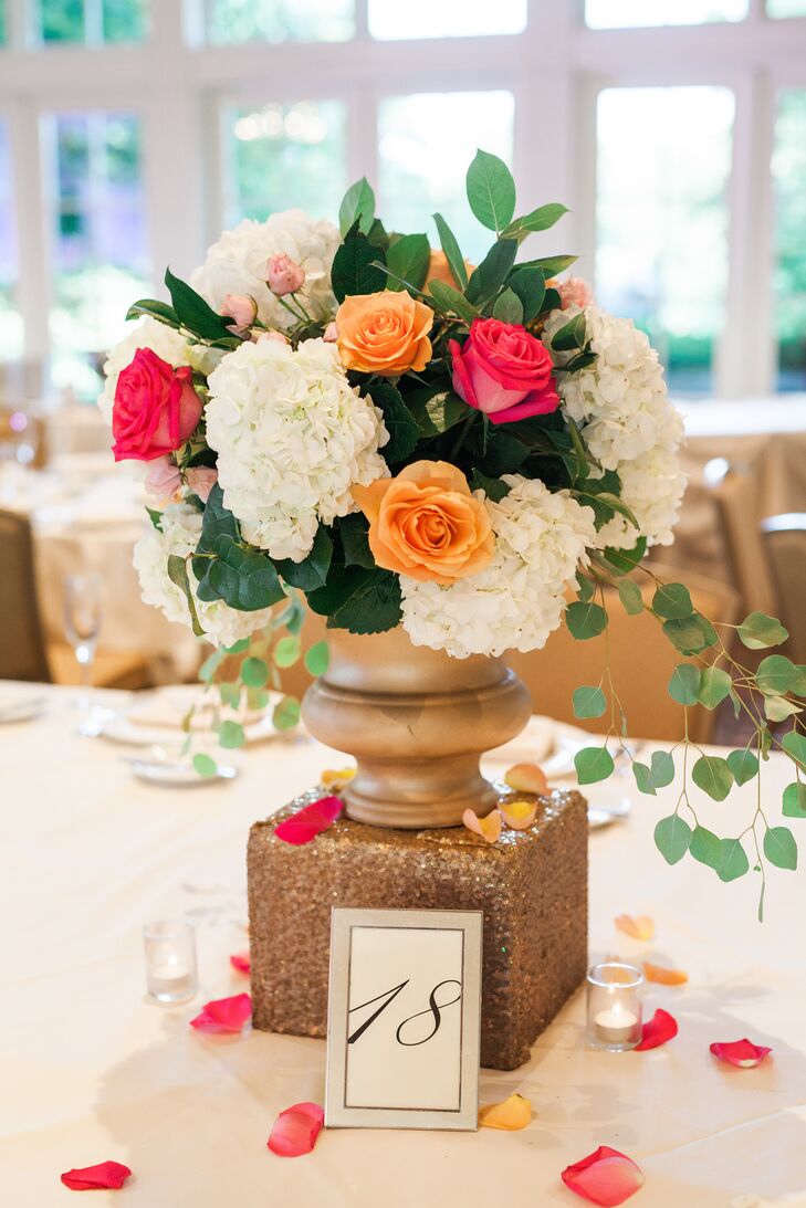 At the Hindu reception, simple low floral centerpieces in bronze urns topped each white linen-covered table.